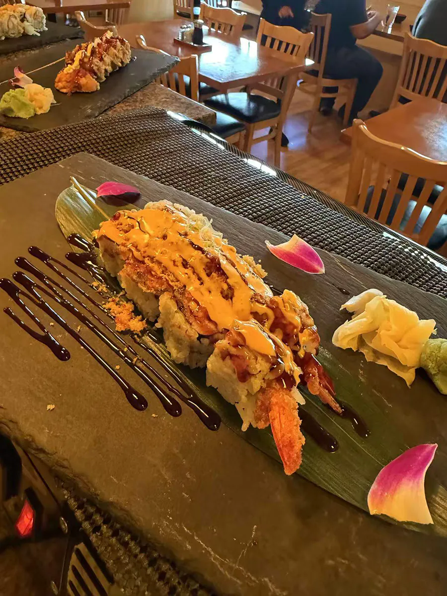 Tempura shrimp sushi roll with two sauces and flower petals at Sake House 2，a Japanese Restaurant in Jacksonville